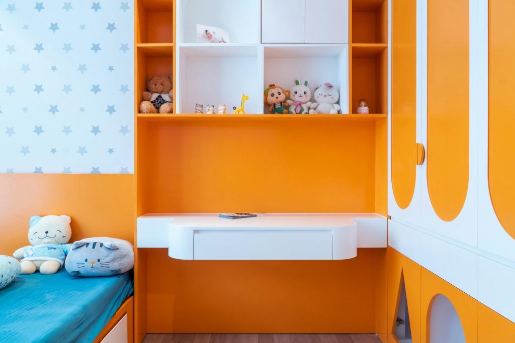 chetoi renovation toulouse chambre d'enfant très colorée, avec orange, blanc et motifs d'étoiles sur les murs. Décoration avec plusieurs peluches